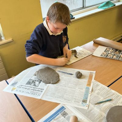 Children making clay lizards